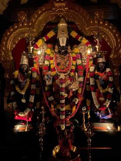 the statue is decorated with flowers and other decorations on it's sides, along with candles