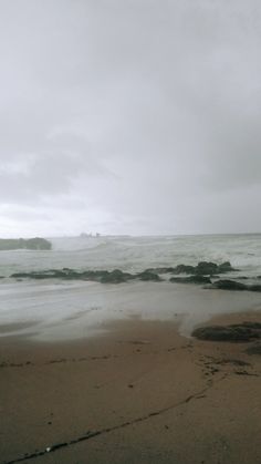 an empty beach with waves coming in to shore