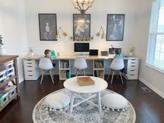 a living room filled with furniture and a white table in front of a computer desk