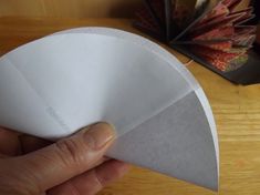 a person is holding an origami piece in their left hand, with the paper folded over it