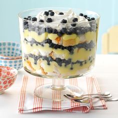 a trifle with blueberries and cream in a glass bowl