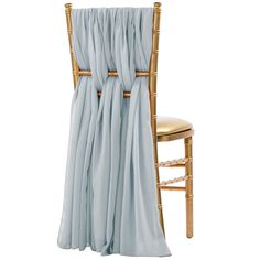 a gold chair with a light blue drape draped over it's seat and back