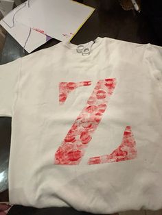 a white t - shirt with the number seven painted on it, sitting on a table