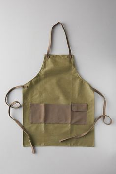 an apron with two pockets on the front and one pocket on the back, sitting on a white surface