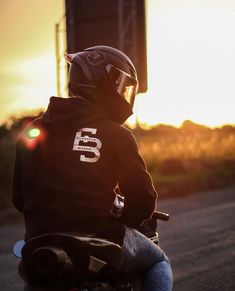 a person on a motorcycle with the sun setting in the background behind them and there is no image here to provide a caption for