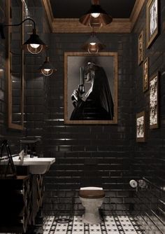 the bathroom is decorated in black and gold with pictures on the brick wall above it