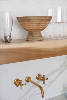 a shelf with wine glasses and a bowl on it