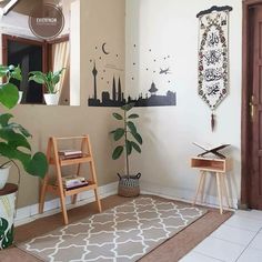 a living room with a rug, potted plants and a wooden ladder on the floor