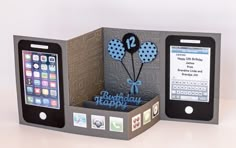 an open box with two cell phones in it and a happy birthday greeting card inside