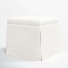 a white square stool sitting on top of a white floor