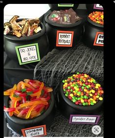 halloween candies and candy are on display in black containers