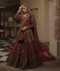 a woman in a red and gold bridal gown standing on a checkered floor