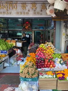 an outdoor market with lots of fresh fruits and vegetables on display in front of the store