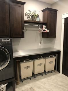 a washer and dryer in a laundry room with cabinets on the wall above them