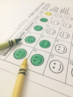 a pencil sitting on top of a sheet of paper with smiley faces drawn on it