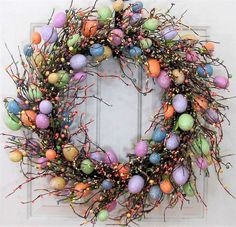 an easter egg wreath is hanging on the front door