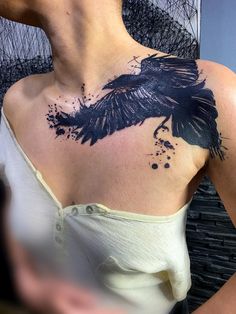 a woman with a black bird tattoo on her chest