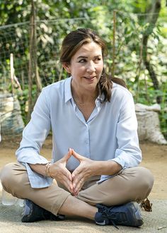 a woman sitting on the ground with her hands together