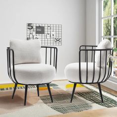 two white chairs sitting next to each other on top of a rug in front of a window