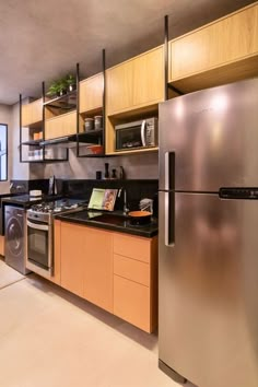 a modern kitchen with stainless steel appliances and wood cabinets, along with black counter tops