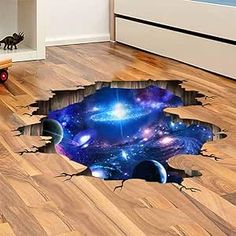 a hole in the floor that has been painted with space and stars