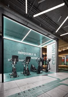 an indoor gym with treadmills and exercise bikes in the background, there is a sign that reads impossible is nothing