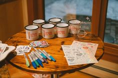 coffee mugs and markers are sitting on a table