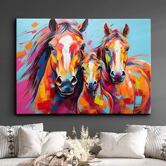 two horses are standing next to each other in front of a painting on the wall