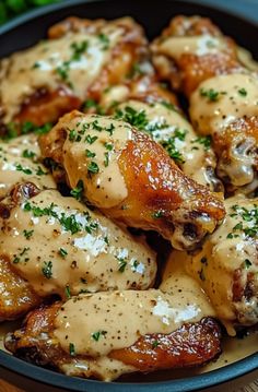 chicken wings covered in gravy and garnished with parsley