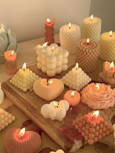 many candles are arranged on a wooden board