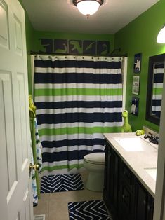 a bathroom with green walls and blue and white shower curtain