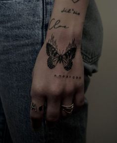 a woman's hand with a butterfly tattoo on it and the words, love is in the air