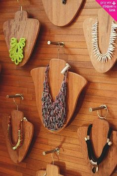 there are many wooden necklaces hanging on the wall with different shapes and sizes in them