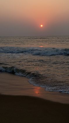 the sun is setting over the ocean with waves