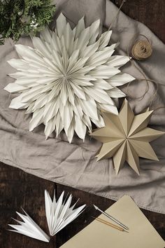 three paper snowflakes are sitting on a table