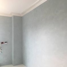 an empty room painted in light blue with white trim and no one around the corner