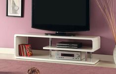 a flat screen tv sitting on top of a white entertainment center next to a purple wall