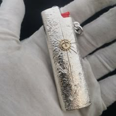 a silver purse sitting on top of a white glove