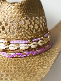 Did someone say coastal cowgirl summer??? Beach day? Country concert? Girls trip? Our handmade cowgirl hats are the PERFECT accessory for any outfit! The Kohana (or Little Flower) Hat is a tan straw cowgirl hat decorated with purple & gold ribbon, plain cowrie shells, & gold chain. Beige Straw Hat For Western-themed Summer Events, Handmade Gold Summer Hats, Gold Festival Hat Bands For Summer, Bohemian Pink Hat Band For Beach, Pink Western Straw Hat For Summer, Pink Country Style Hat Band For Summer, Pink Western Style Sun Hat For Festivals, Country Style Pink Beach Hat, Country Style Pink Hat Bands For Summer