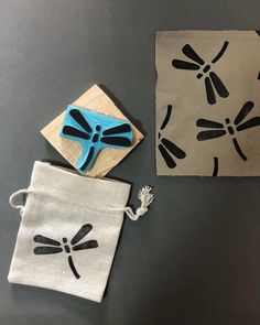 two pieces of cloth with dragonfly designs on them and a blue object in the middle