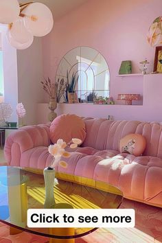 a living room with pink couches and round mirrors on the wall, along with flowers in a vase