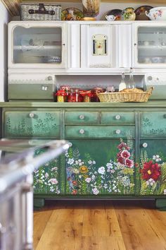 an old dresser painted with flowers and plants