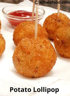 four fried food items on a white plate with toothpicks in them and ketchup