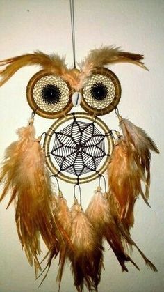 an owl shaped dream catcher hanging on the wall