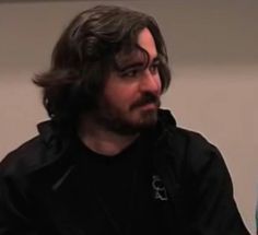 a man with long hair and beard sitting down