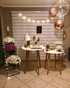 two tables with desserts on them in front of a garage door and balloons hanging from the ceiling