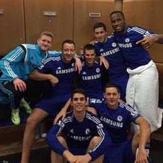 the soccer team is posing for a group photo in front of locker room doors with their coach