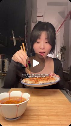 a woman is eating pizza with chopsticks in her hand and holding a plate