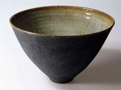 a black and gray bowl sitting on top of a white table