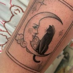 a black cat sitting on top of a crescent moon